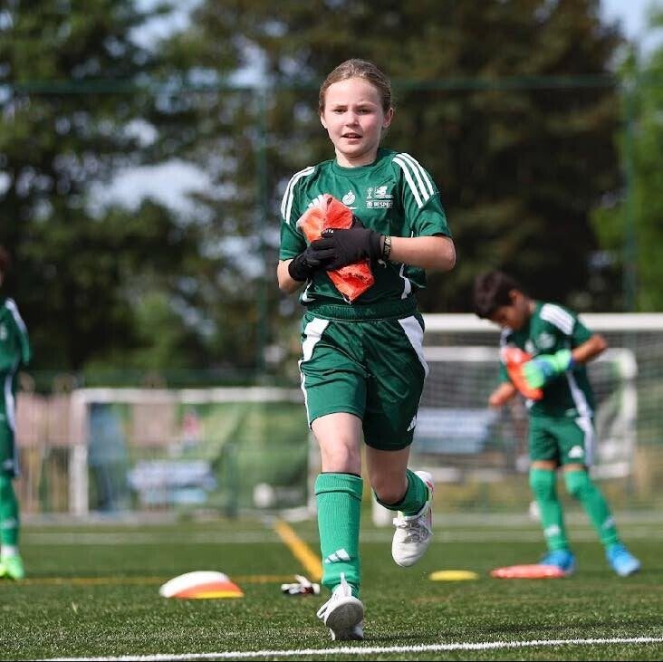 Meisje loopt met de bal aan de voet tijdens het junior camp